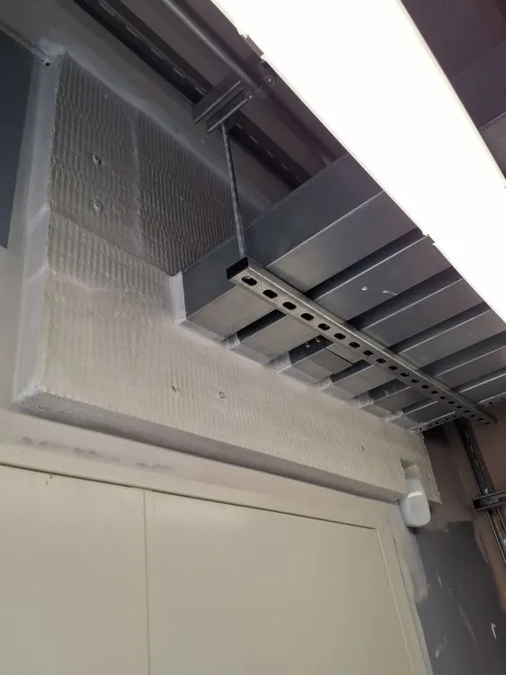 Fire-resisting board fitted around services and structural steel above a ceiling