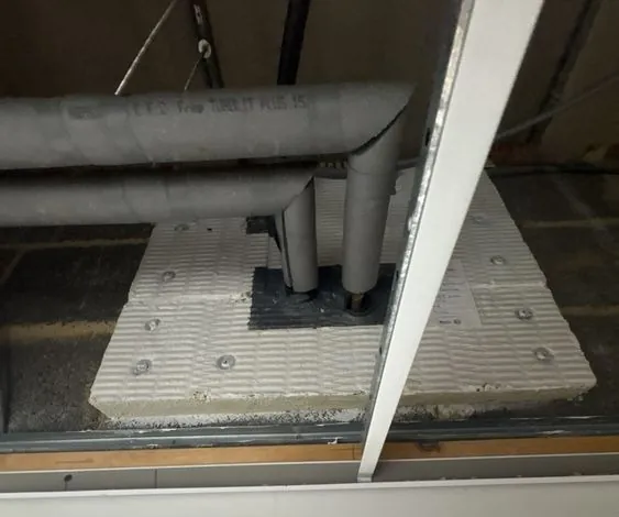 Insulated pipes passing through a floor, sealed with a fire batt